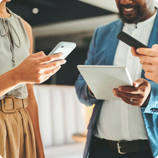 A group of people in conversation holding cell phones.