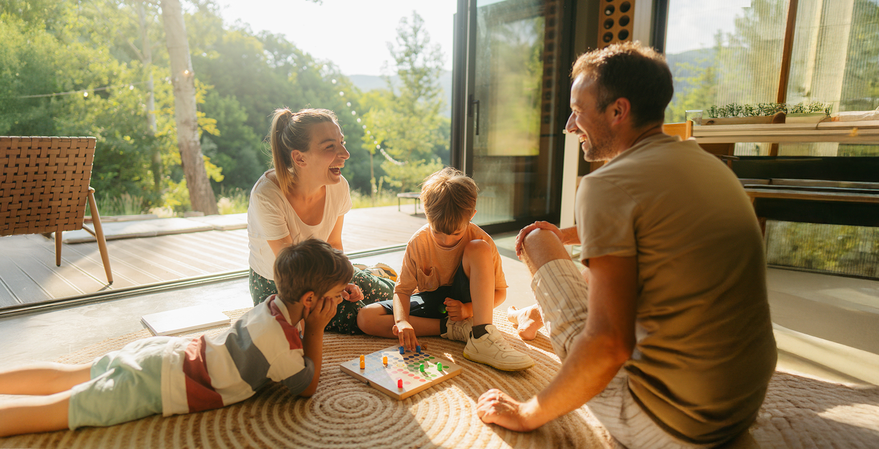 Mom, Dad, and two young kids playing a game on the living room floor.